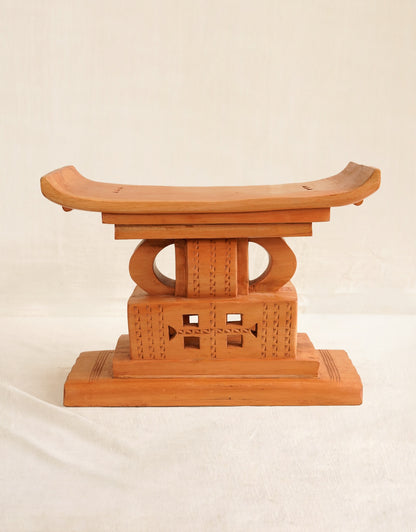 Wooden stool with a decorative top on a beige background