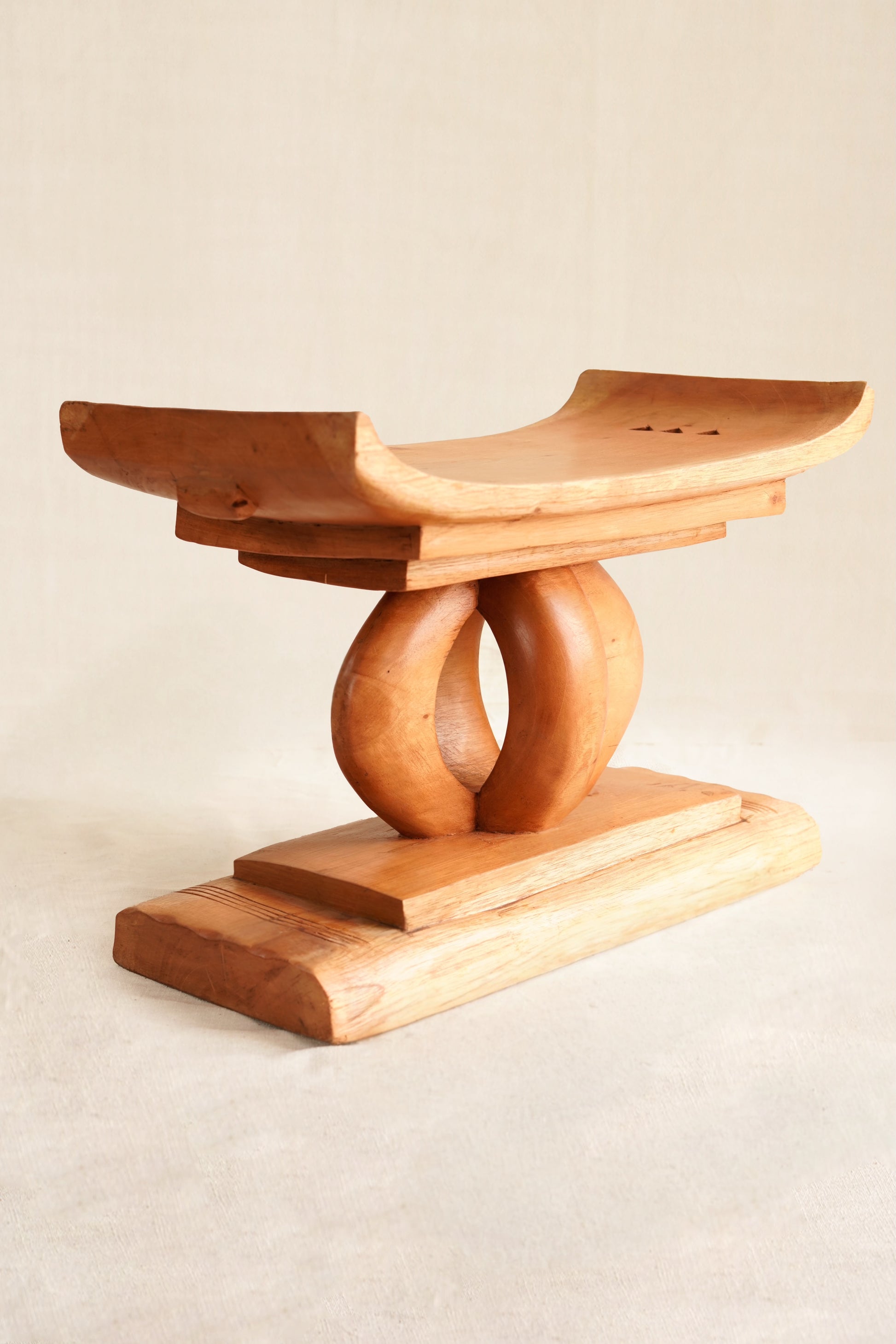 Wooden stool with a unique design on a beige background