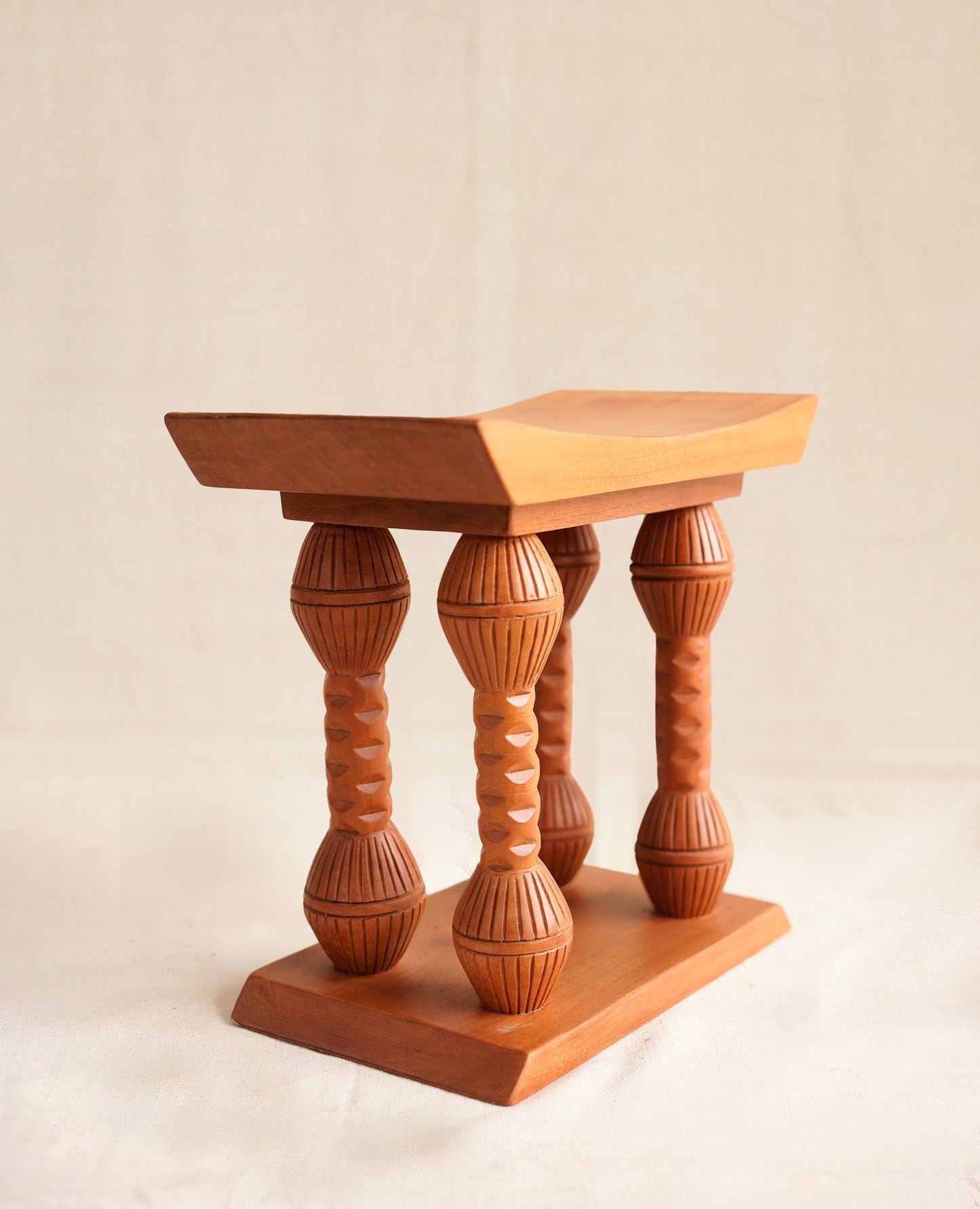 Wooden stool with a unique design on a plain background