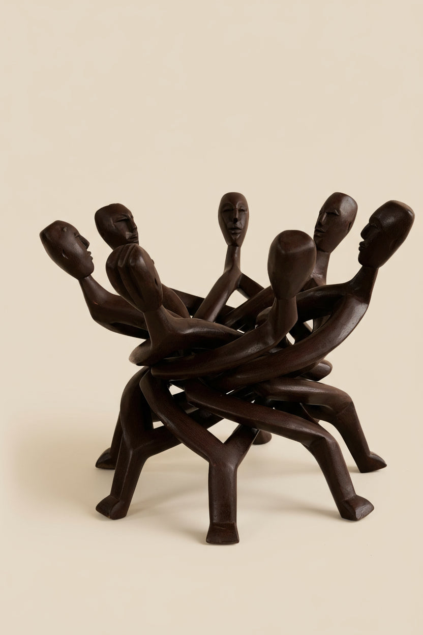 Wooden sculpture of interlocking figures on a beige background