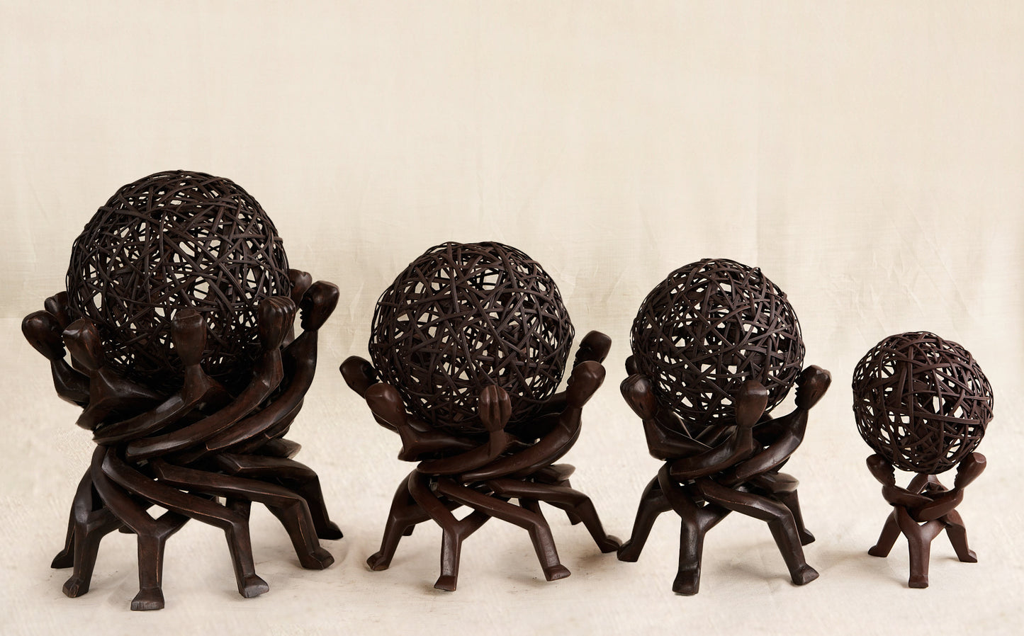 Wooden sculpture of interlocking figures on a beige background