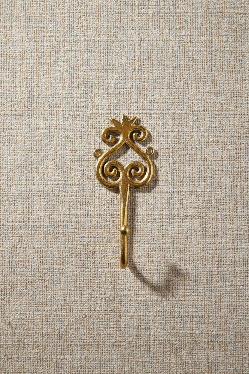 Brass decorative hook on a white background