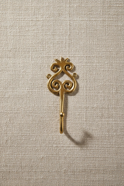 Brass decorative hook on a white background