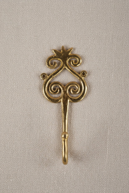 Brass decorative hook on a white background