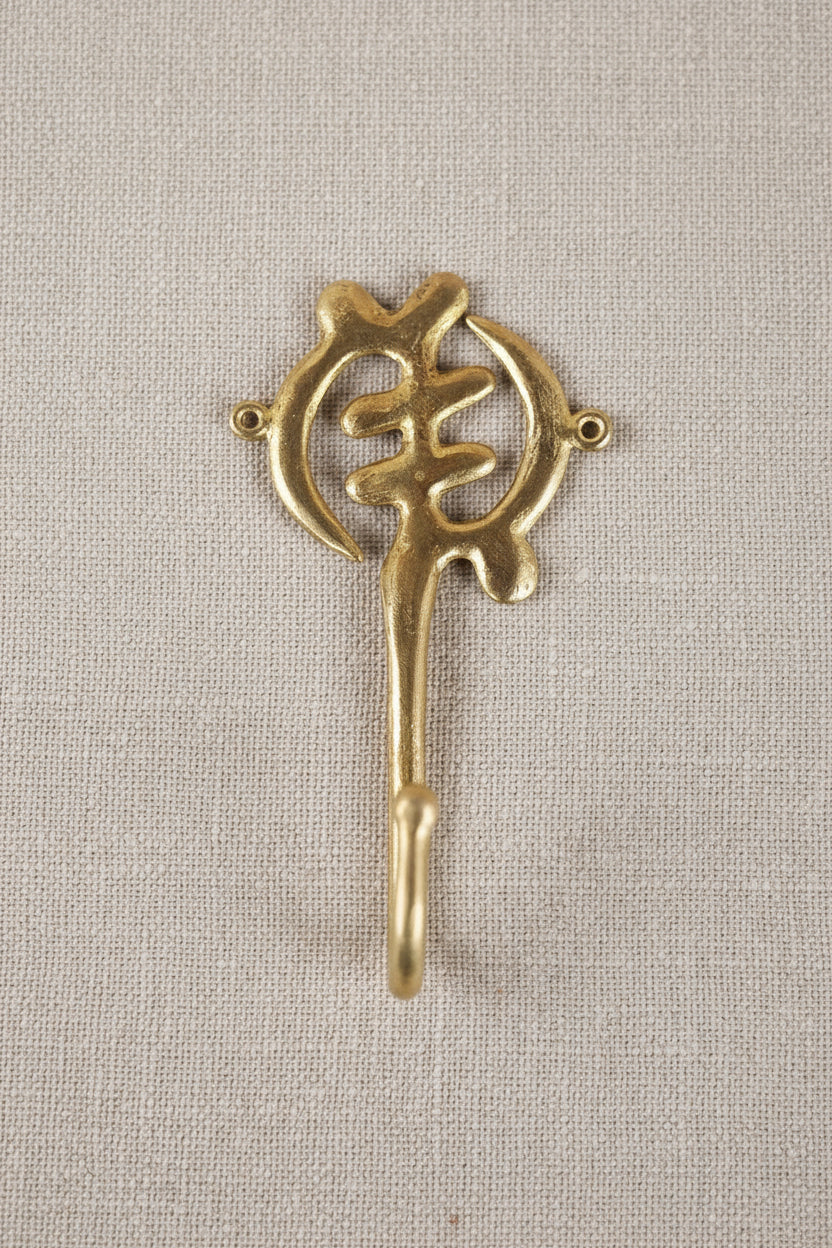 Brass decorative hook on a white background