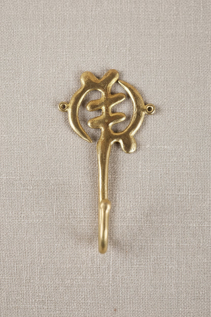 Brass decorative hook on a white background