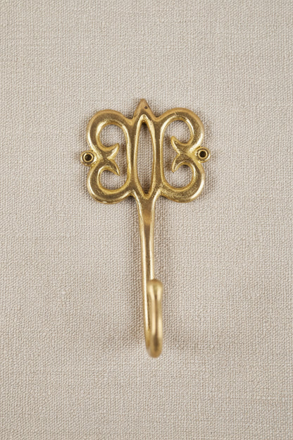 Brass decorative hook on a white background