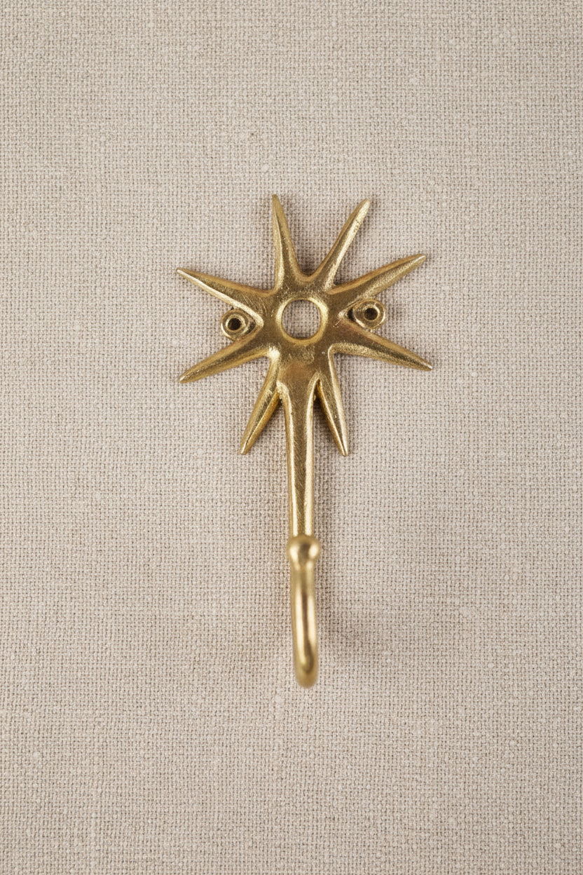 Brass decorative hook on a linen background