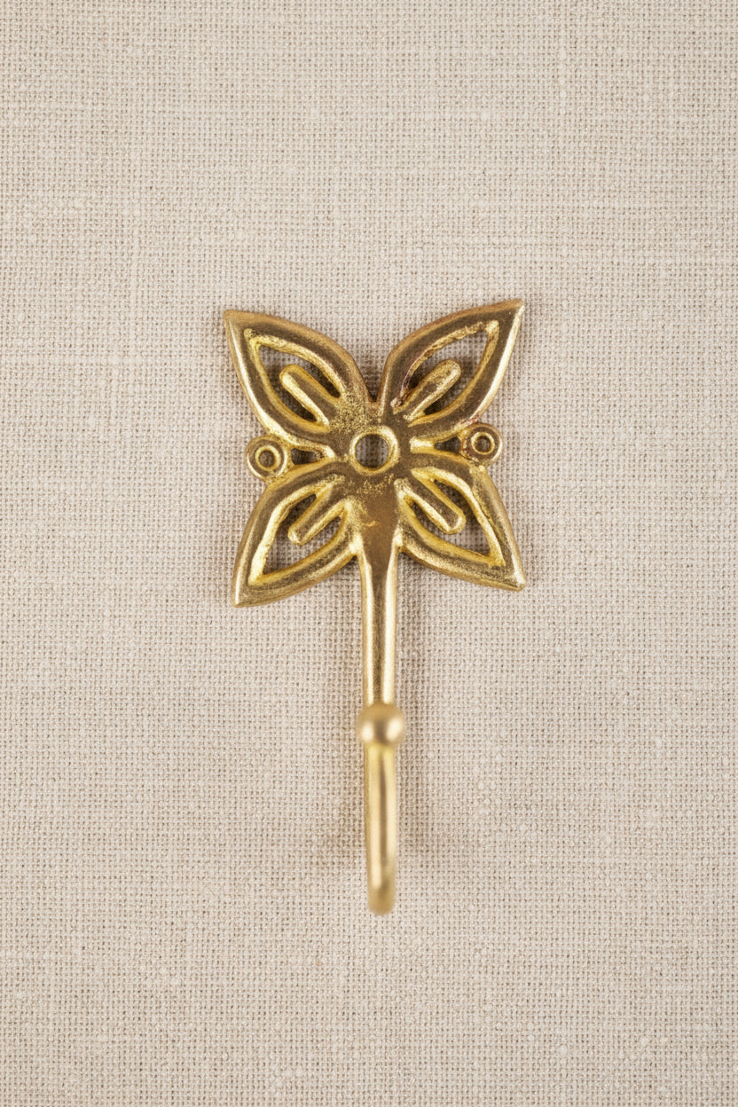 Brass decorative hook on a linen background