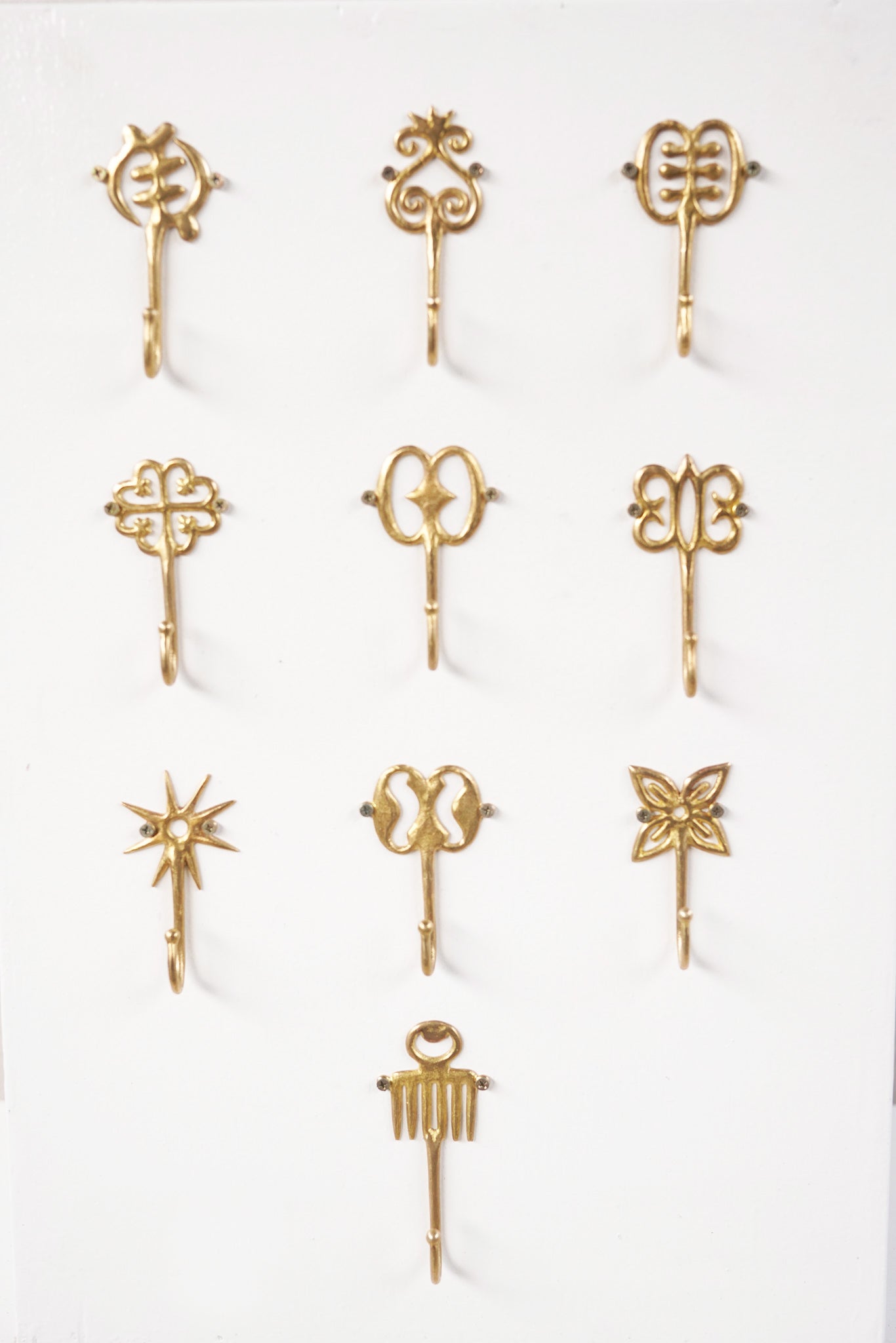 Set of brass decorative hooks on a white background
