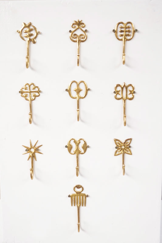 Set of brass decorative hooks on a white background