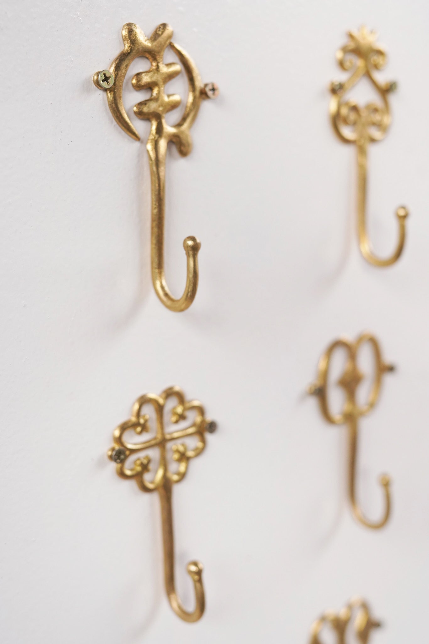 Set of brass decorative hooks on a white background