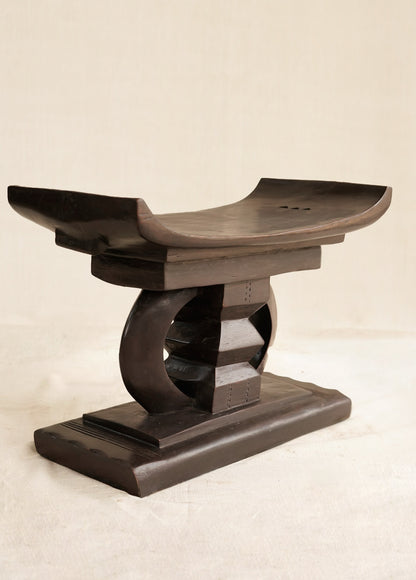 Wooden stool with a curved design on a beige background