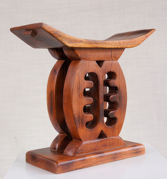 Wooden Ashanti stool with intricate design on a light background