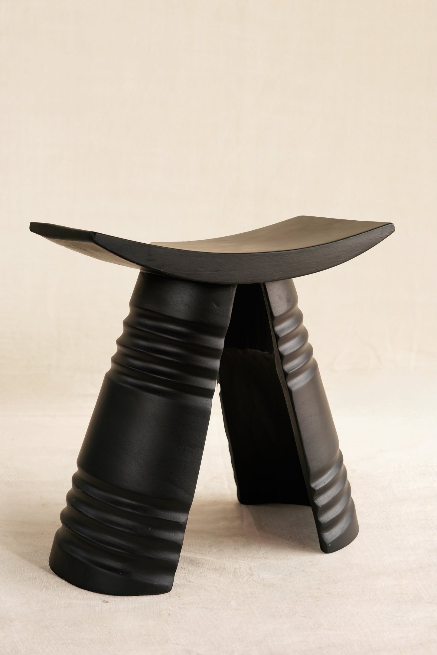 Black stool with unique design on a beige background
