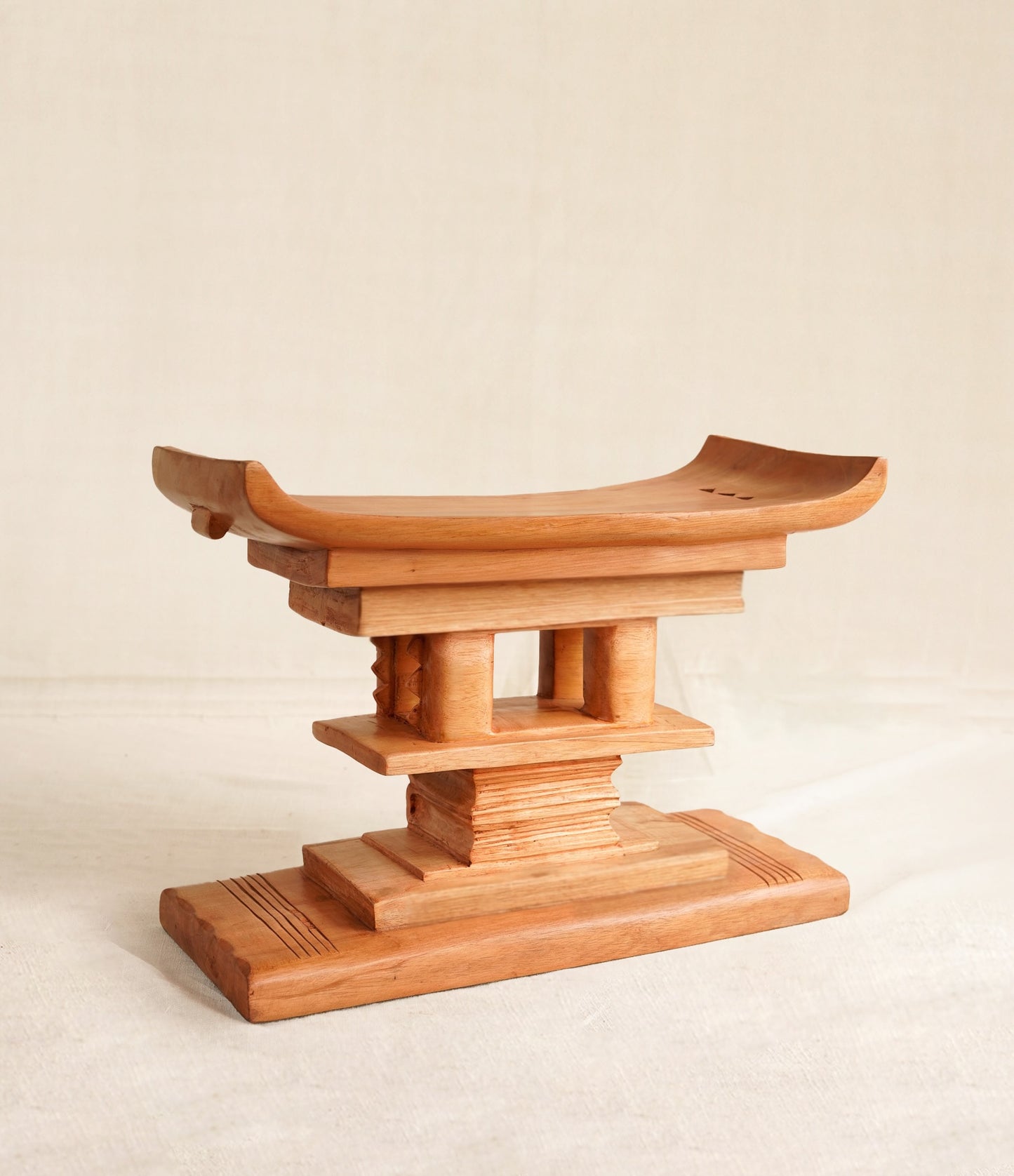 Wooden stool showing a stack of books on  a beige background