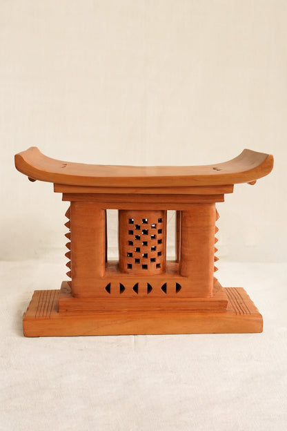 Wooden stool with decorative backrest on a beige background