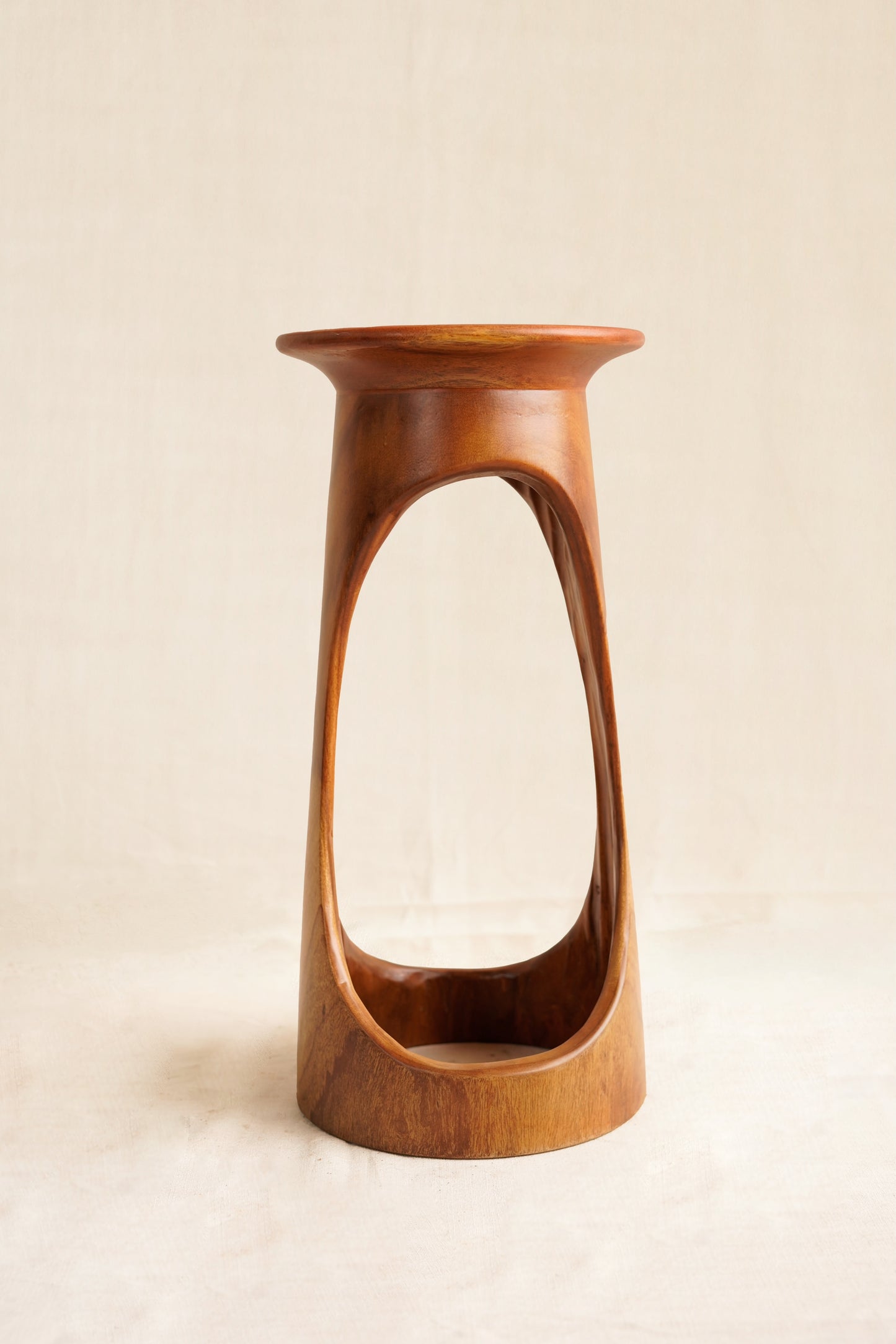Wooden vase with a unique design on a beige background