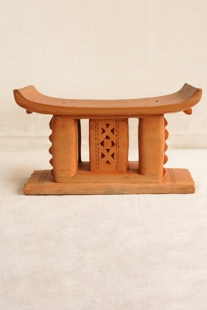 Wooden stool with decorative backrest on a beige background