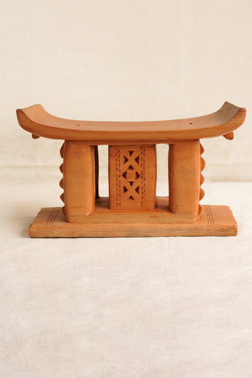Wooden stool with decorative backrest on a beige background