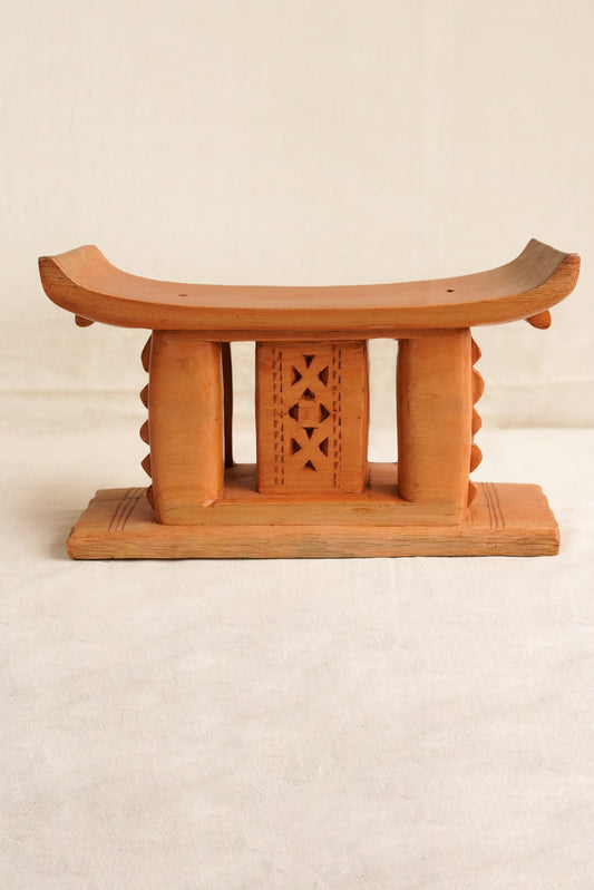 Wooden stool with decorative backrest on a beige background