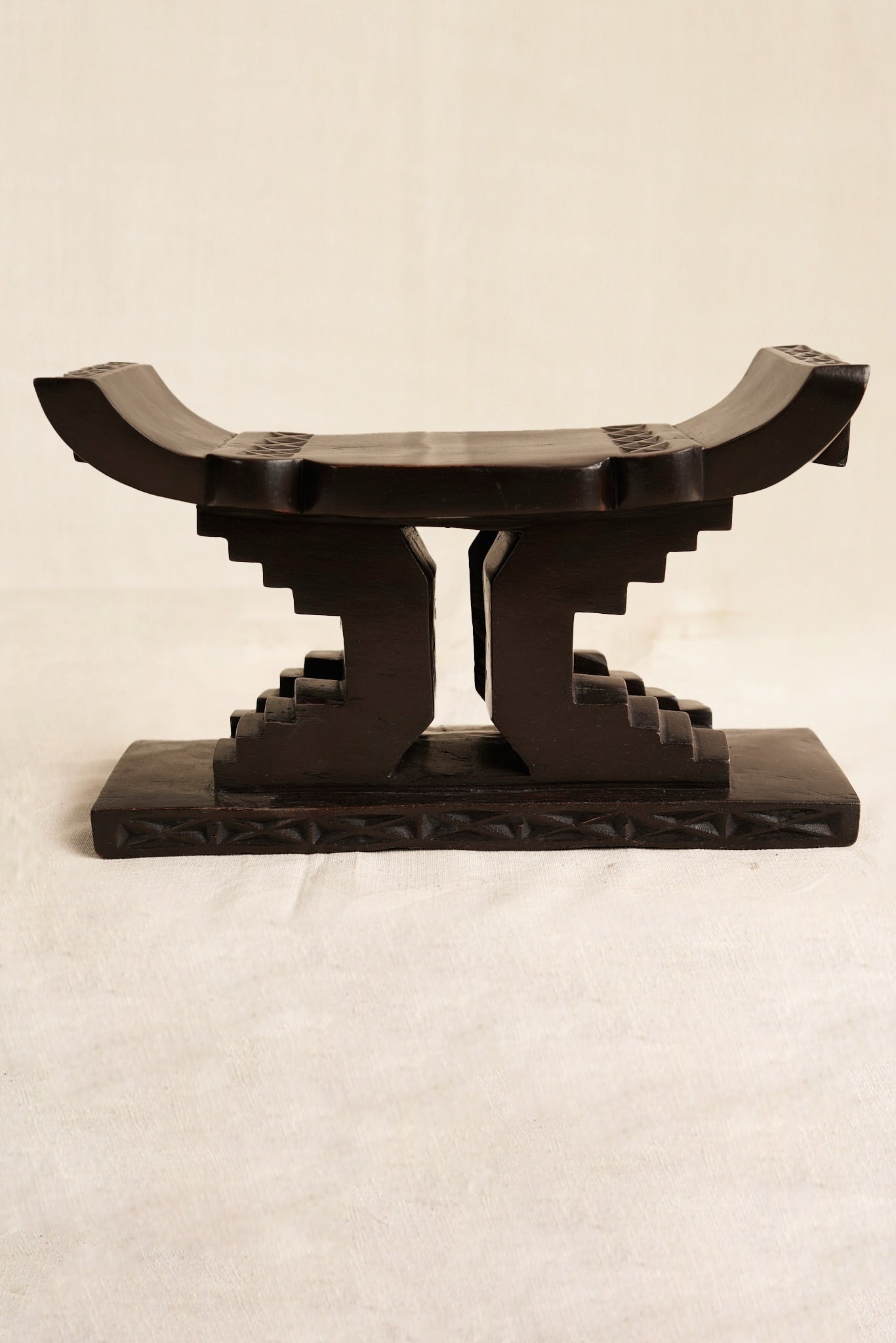 Decorative black Ashanti stool  on a beige background