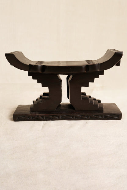 Decorative black Ashanti stool  on a beige background