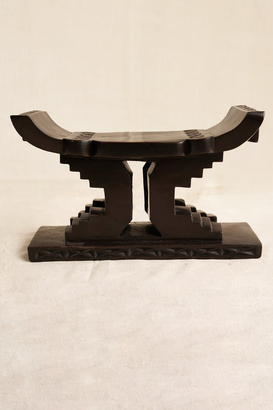 Decorative black Ashanti stool  on a beige background