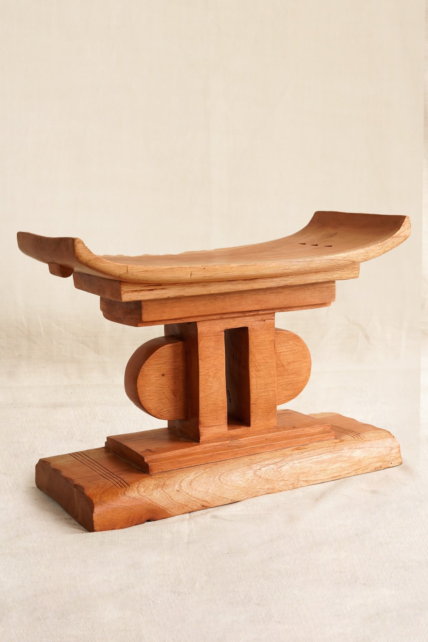 Wooden stool with a traditional design on a beige background