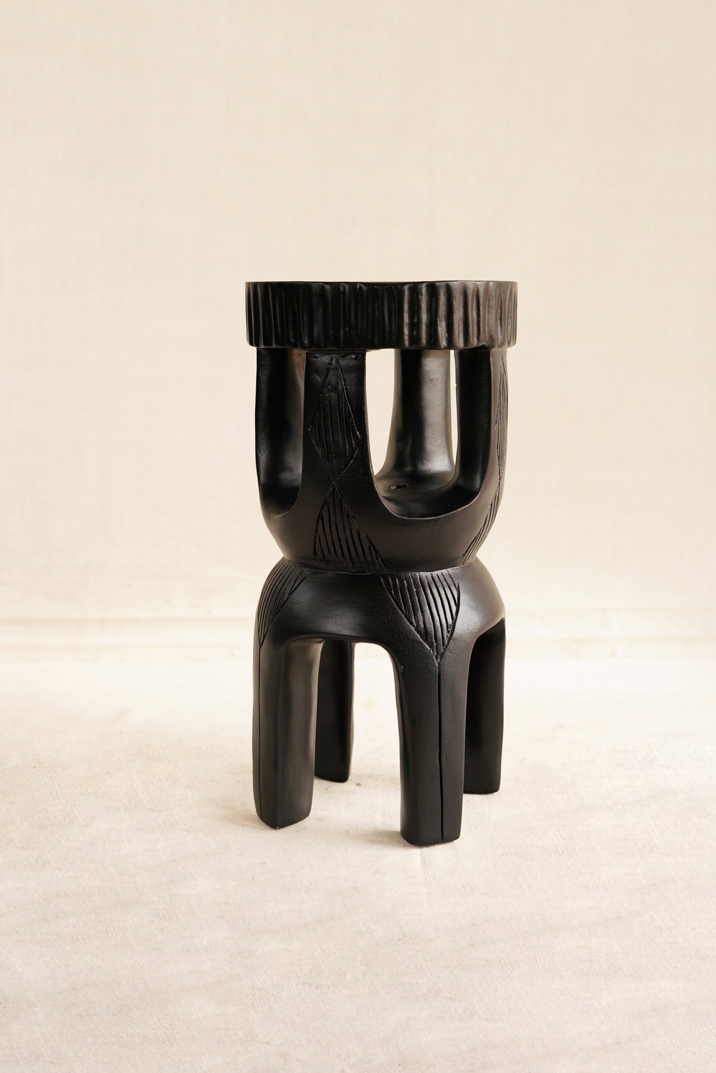 Black abstract stool on a beige background