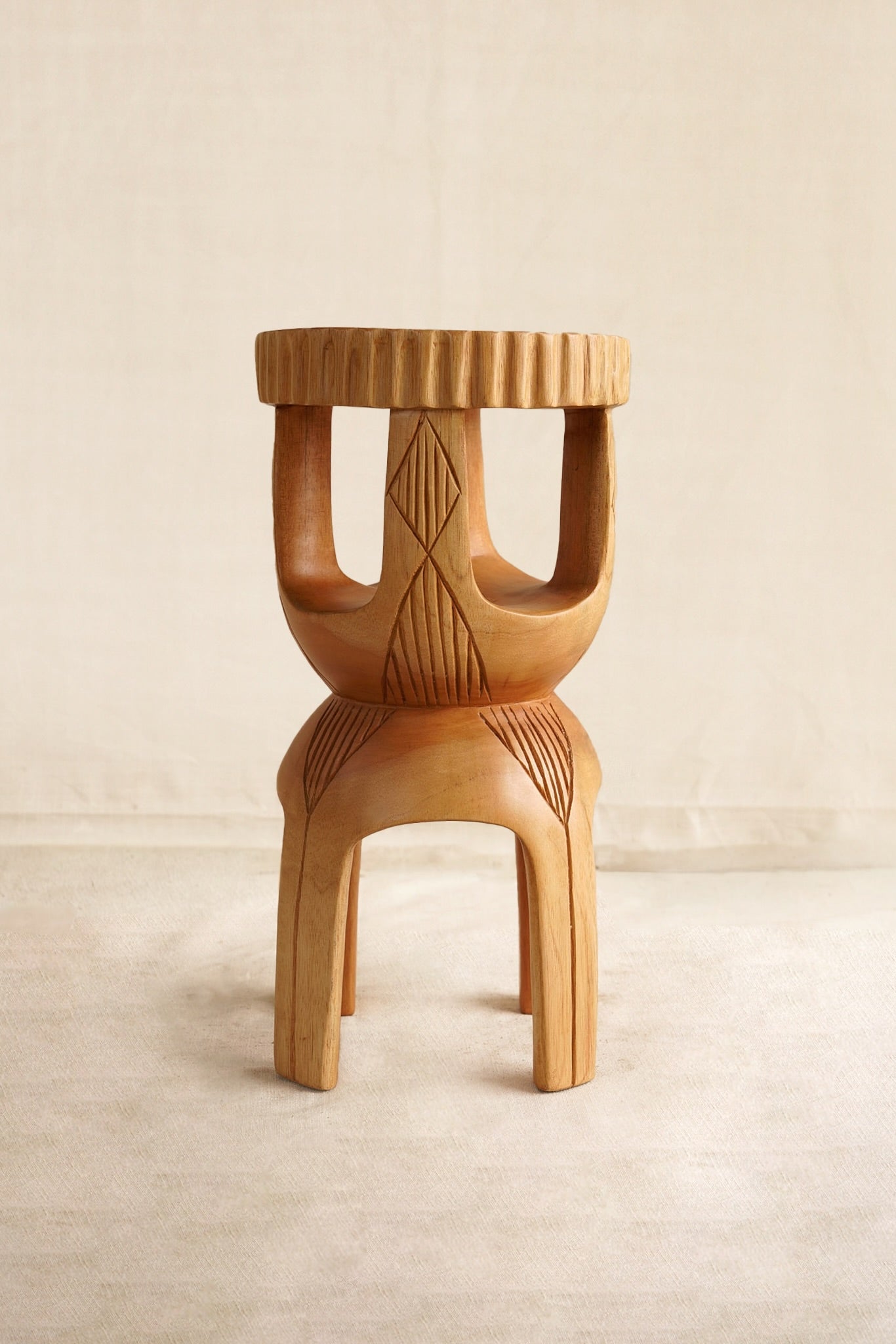 Wooden stool/ table with geometric patterns on a beige background