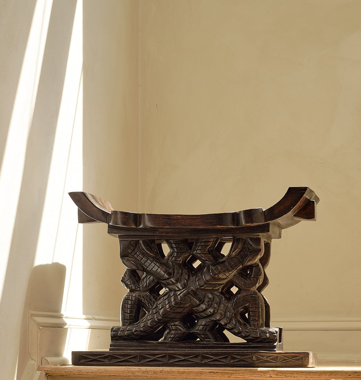 Decorative wooden stool on a staircase with a neutral background