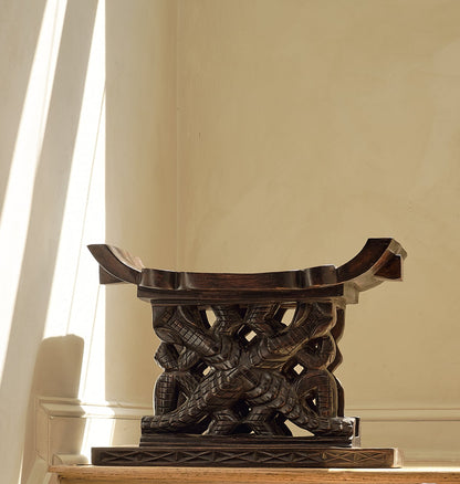 Decorative wooden stool on a staircase with a neutral background