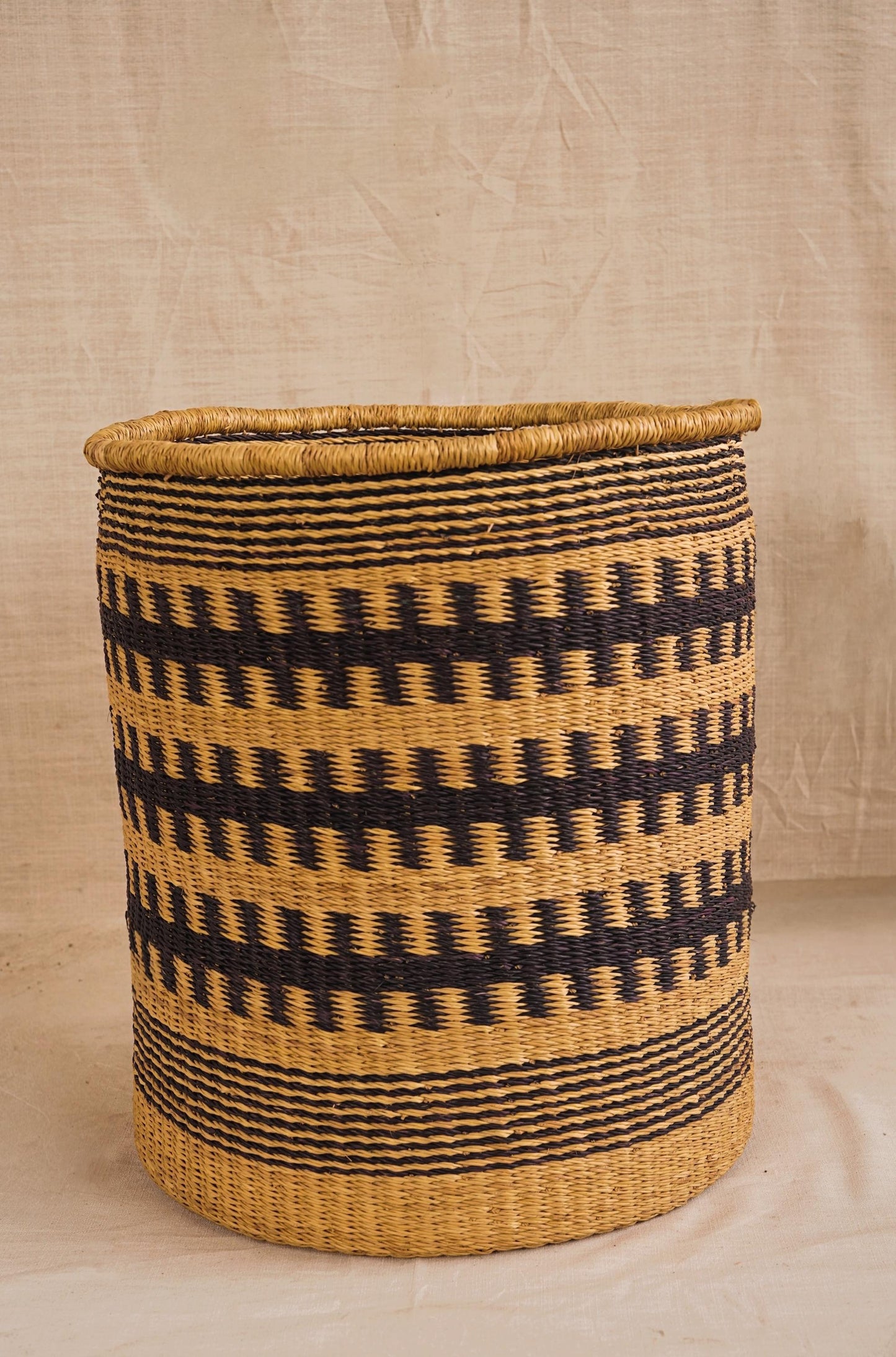 Woven basket with geometric pattern on plain background