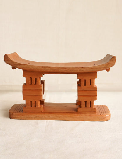 Wooden stool with a traditional design on a beige background