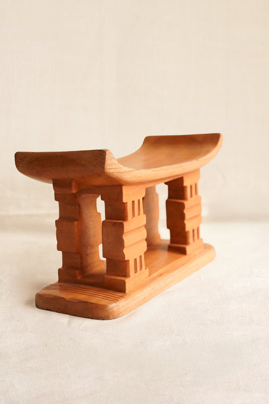 Wooden stool with a minimalist design on a plain background