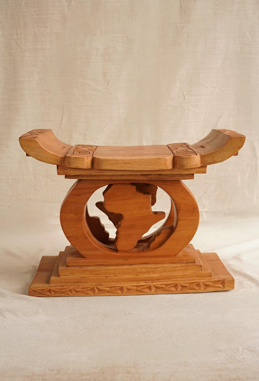 A hand-carved wooden Ashanti stool from Ghana, with a curved seat and arched base, featuring detailed motifs. Map of Africa Ashanti Stool