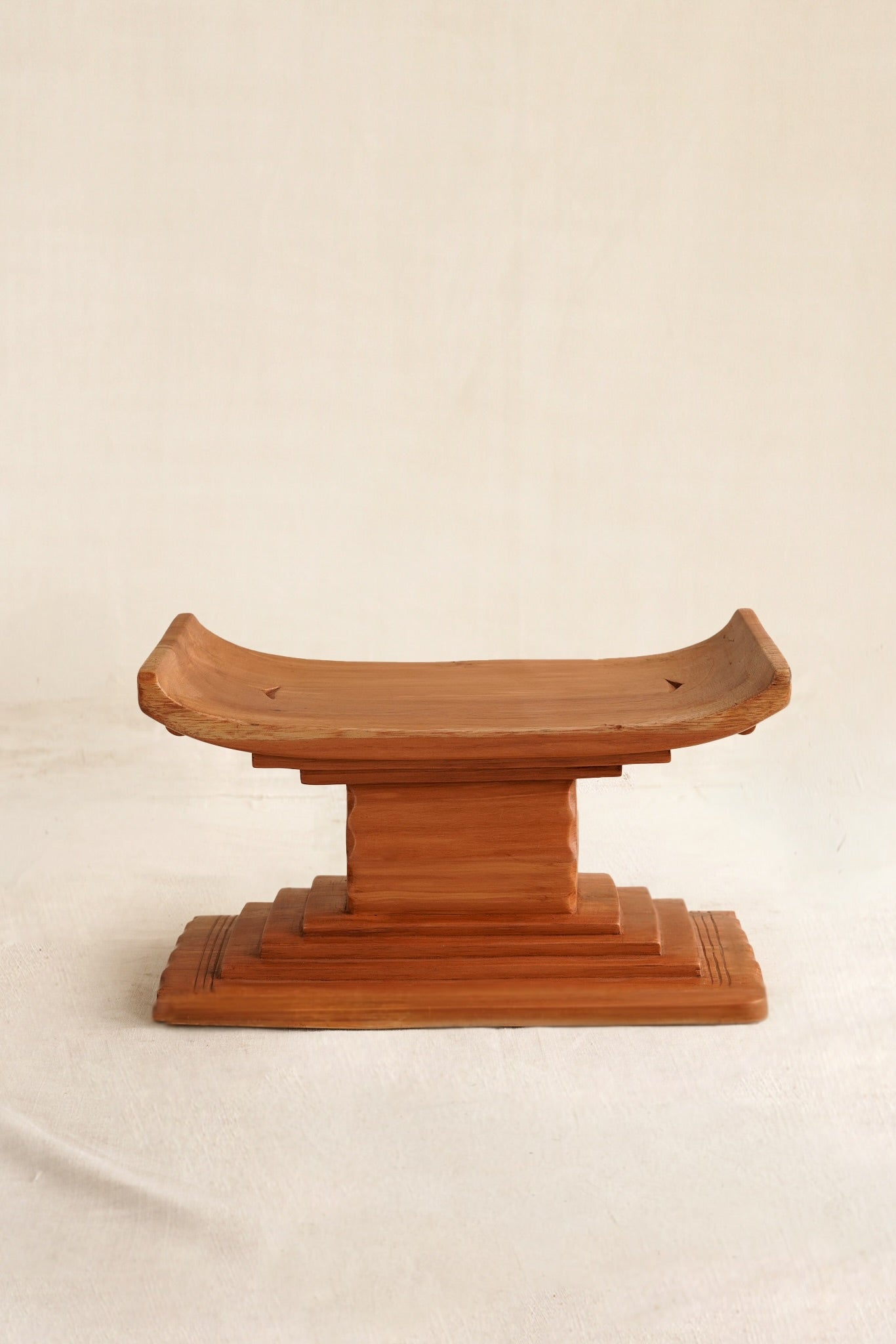 Miniature Ashanti stool with handmade in Ghana on a linen backdrop