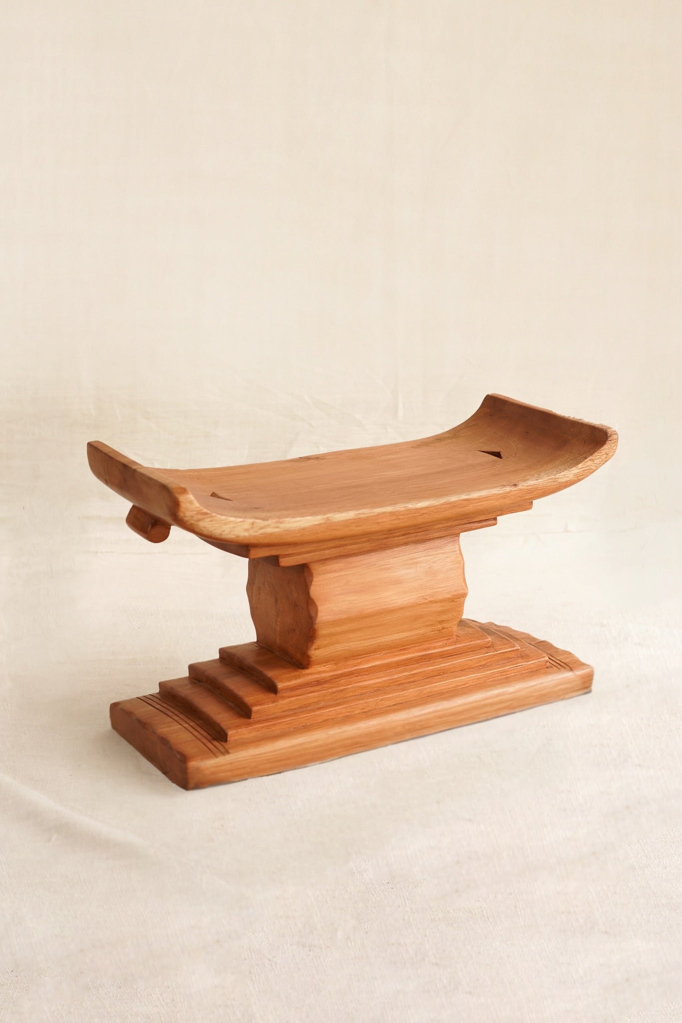 Miniature Ashanti stool with handmade in Ghana on a linen backdrop