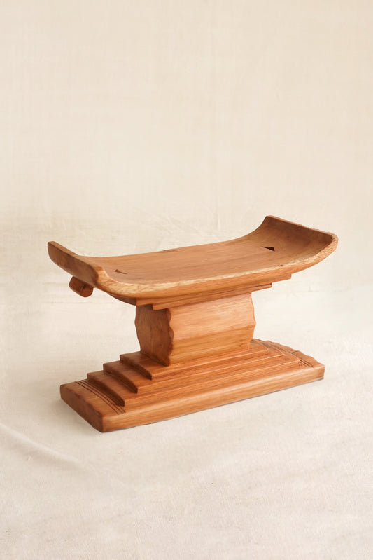 Miniature Ashanti stool with handmade in Ghana on a linen backdrop
