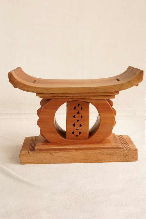 Wooden stool with a decorative design on a beige background