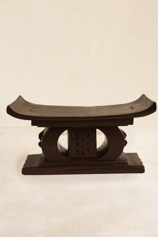 Decorative black Ashanti stool  on a beige background
