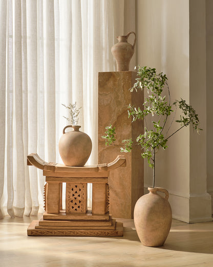 Decorative Natural Ashanti stool  on a beige background stagger with 3 Pots, a pedestal and a branch 