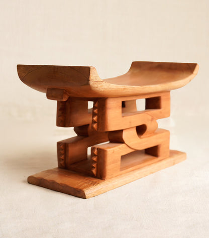 Wooden stool with a geometric design on a beige background