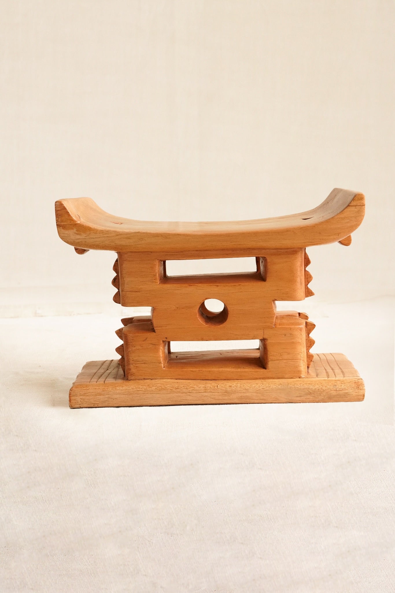 Wooden stool with a traditional design on a beige background