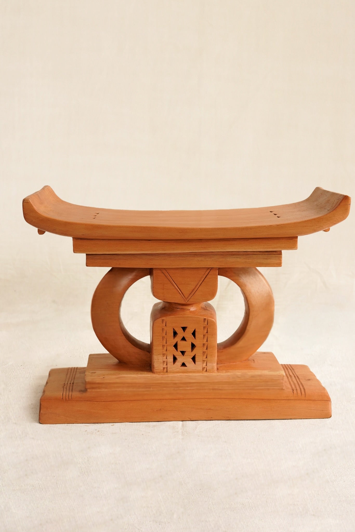 Wooden stool with a traditional design on a beige background
