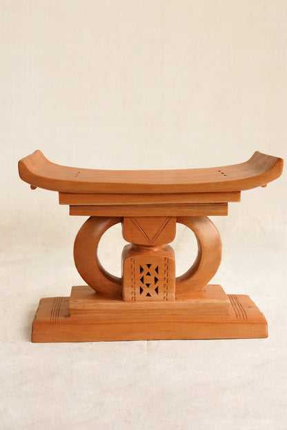 Wooden stool with a traditional design on a beige background