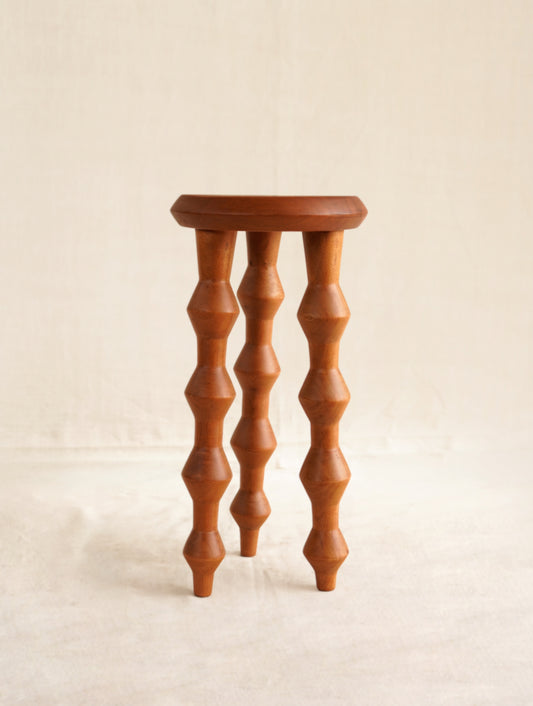 Wooden stool with spiral legs on a beige background