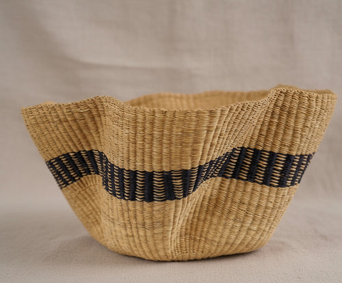 Woven basket with a black strip on a white background