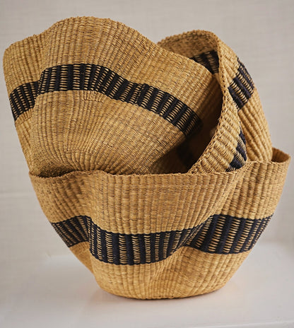Woven basket with black straps on a light background